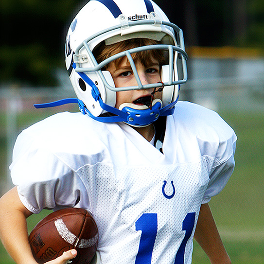 kid playing football with mouthguard